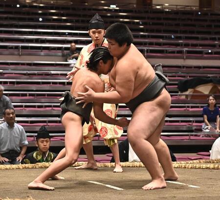 立ち合いで松の里（右）に頭からぶつかる新道（撮影・開出牧）