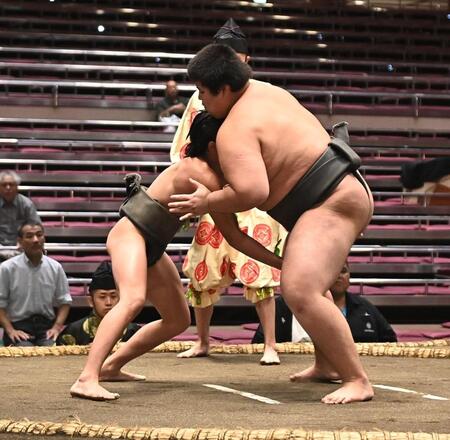 立ち合いで松の里（右）に頭からぶつかる新道（撮影・開出牧）
