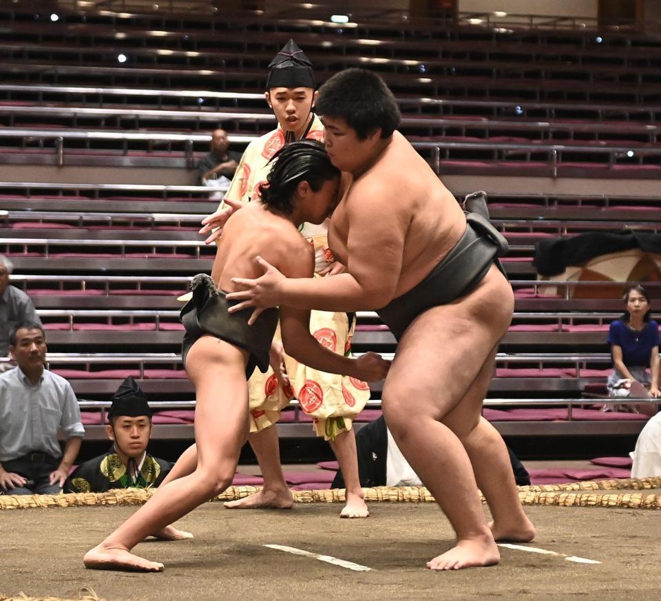 立ち合いで松の里（右）に頭からぶつかる新道（撮影・開出牧）