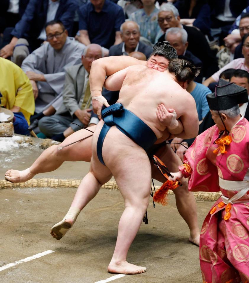 安青錦（手前）の攻めをこらえる伯乃富士。押し出しで破る