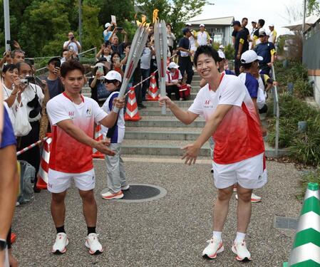 聖火を受けポーズをとる水谷隼さん（右）