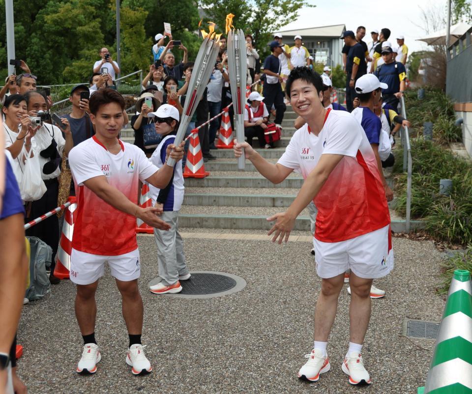聖火を受けポーズをとる水谷隼さん（右）