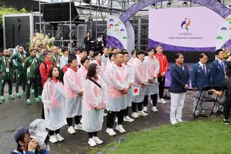 アジア大会の歓迎式典で日の丸掲揚を見る日本選手団（中央）ら
