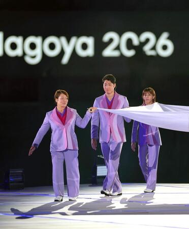 愛知・名古屋アジア大会の開会式で大会旗を運ぶ（左から）谷本歩実さん、萩野公介さん、吉田沙保里さん
