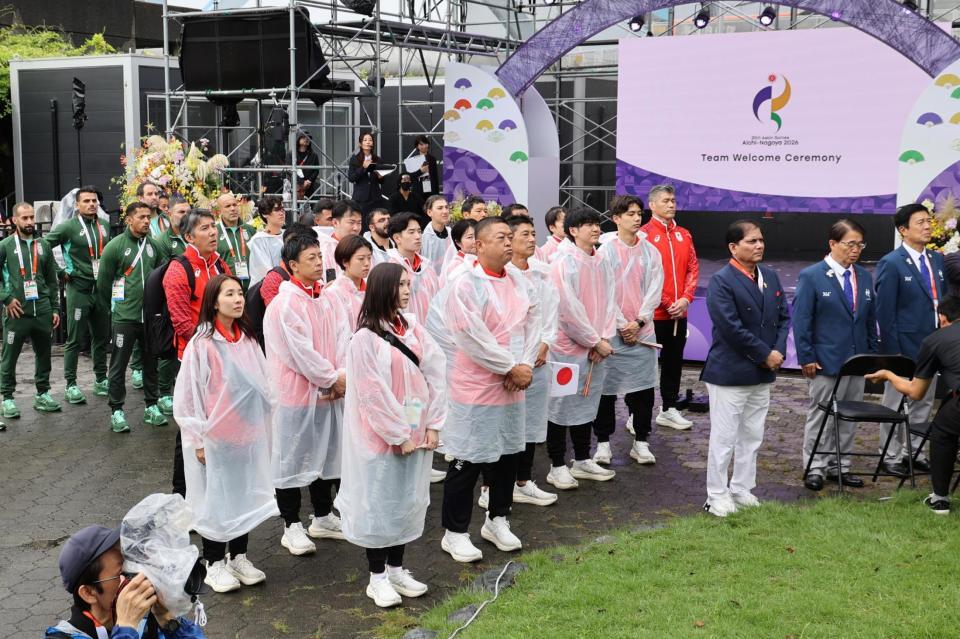 アジア大会の歓迎式典で日の丸掲揚を見る日本選手団（中央）ら