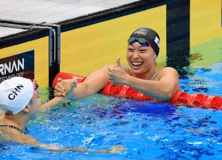女子５０メートル平泳ぎで、中国選手と健闘をたたえ合う銀メダルを獲得した鈴木聡美（右）