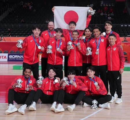 銀メダルを手に記念撮影に納まるバスケットボール男子の選手たち