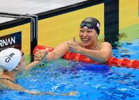女子５０メートル平泳ぎで、中国選手と健闘をたたえ合う銀メダルを獲得した鈴木聡美（右）