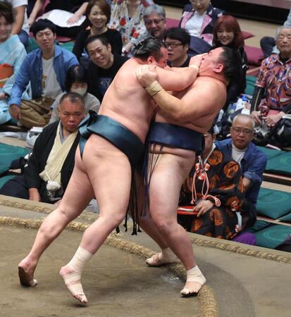 北の若（左）の攻めをこらええう玉鷲（撮影・佐々木彰尚）