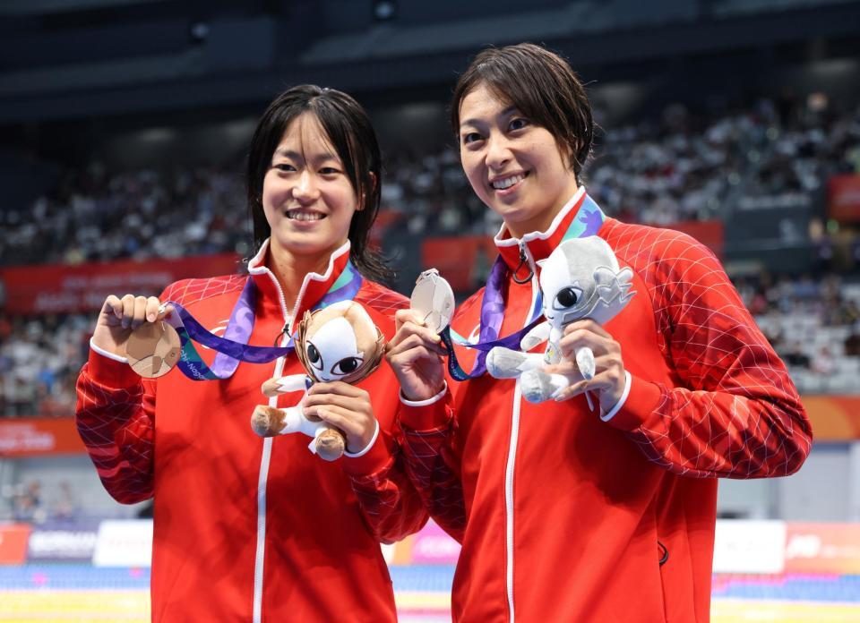 女子１００ｍ平泳ぎの表彰を終え、メダルを手に笑みを浮かべる加藤心冨（左）と鈴木聡美（撮影・伊藤笙子）