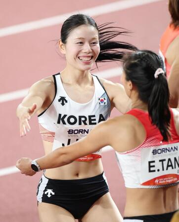 女子１００メートル準決勝を走り終え、笑顔を見せる韓国のキム・ジュハ（左）＝撮影・中田匡峻