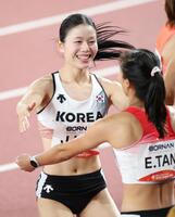 女子１００メートル準決勝を走り終え、笑顔を見せる韓国のキム・ジュハ（左）＝撮影・中田匡峻