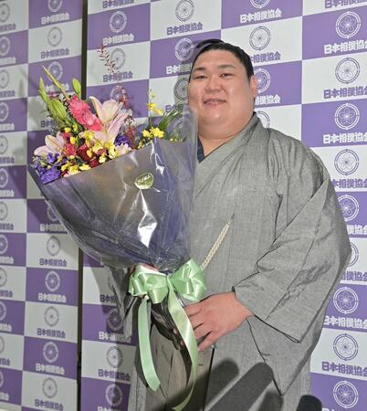 引退会見で花束をもらい笑顔で写真に納まる矢後（撮影・持木克友）