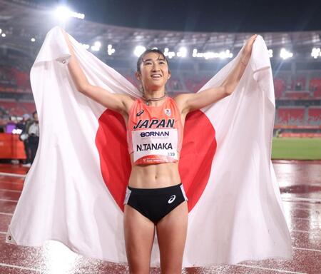 女子１５００メートルで銅メダルを獲得し、日の丸を背に喜ぶ田中希実（撮影・中田匡峻）