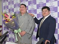引退会見で花束をもらい押尾川親方（右）と笑顔で写真に納まる矢後（撮影・持木克友）
