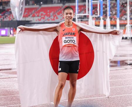男子４００メートル障害で２位となり日の丸を掲げる後藤大樹