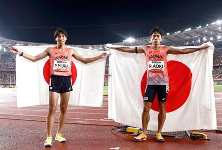 男子３０００メートル障害で優勝し日の丸を掲げる三浦龍司（左）と２位の青木涼真