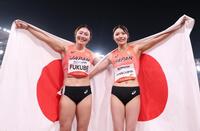 日の丸を背に笑顔を見せる福部真子（左）と中島ひとみ（撮影・中田匡峻）