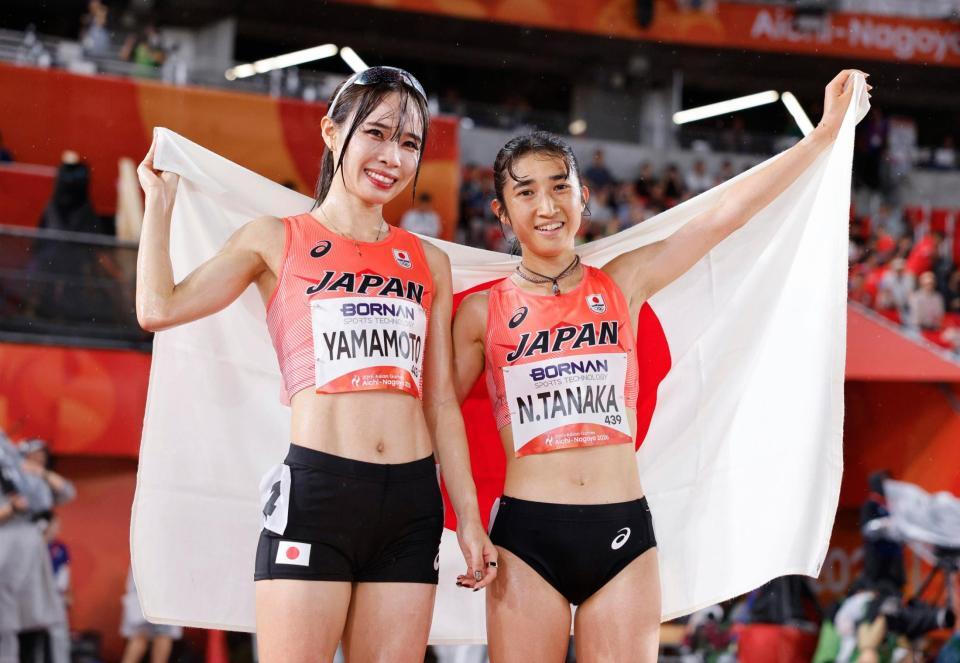 女子５０００メートルを終え、日の丸を掲げる２位の田中希実（右）と４位の山本有真
