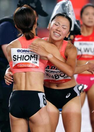 女子８００メートル決勝を終え、塩見綾乃（左）と健闘をたたえ合う久保凜
