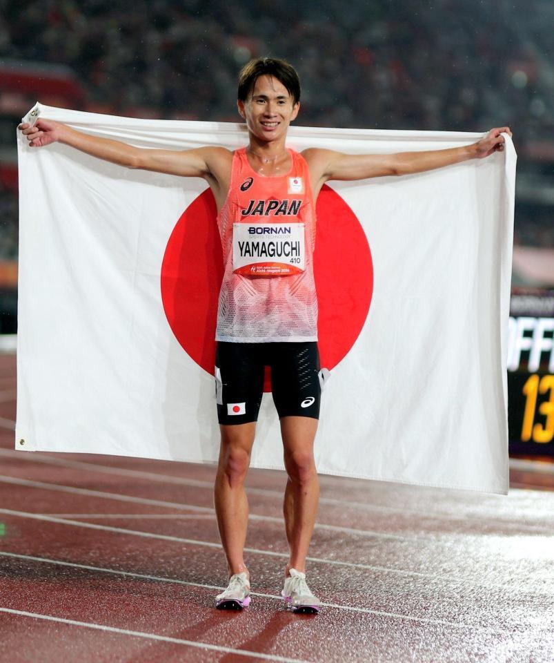 男子５０００メートルで銀メダルを獲得し、日の丸を掲げる山口智規