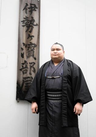 部屋の看板前で撮影に応じる新十両の旭富士