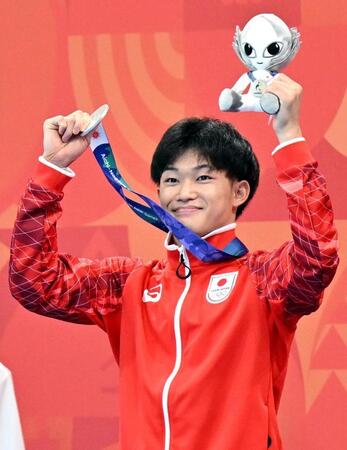 男子高飛び込みで銀メダルを獲得し、歓声に応える玉井陸斗