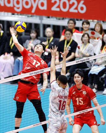 男子準々決勝　日本－カタール　第１セット、スパイクを放つ西本（左）