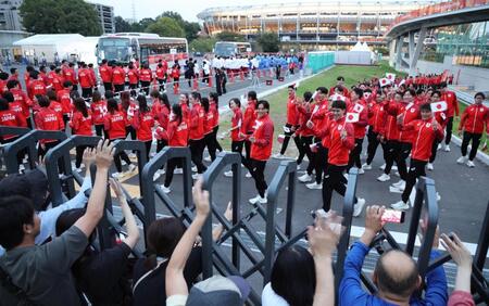 閉会式に参加するため、声援に応えながらパロマ瑞穂スタジアム（奥）へ向かう日本選手団