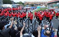 閉会式に参加するため、声援に応えながらパロマ瑞穂スタジアム（奥）へ向かう日本選手団