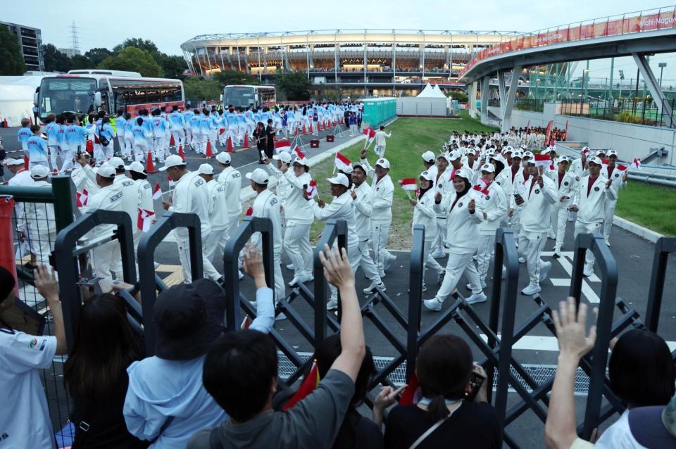 閉会式に参加するため、声援に応えながらパロマ瑞穂スタジアム（奥）へ向かうインドネシア選手団ら