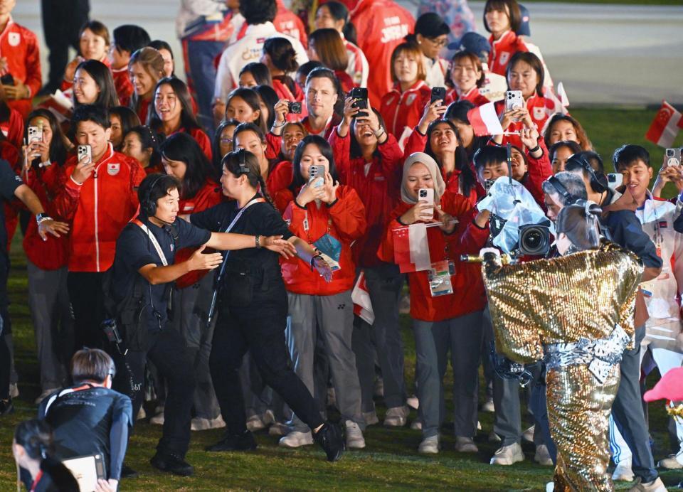 閉会式で「マツケンサンバ２」を披露する松平健さん（右下）にカメラを向ける選手たち