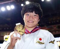 　女子６３キロ級で優勝し、金メダルを手に笑顔を見せる嘉重春樺（共同）