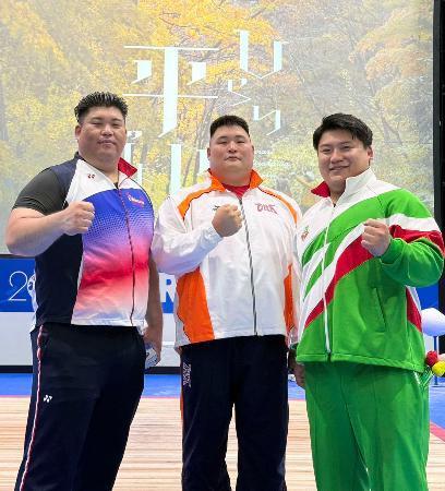 　現役最後の試合を終え、ポーズをとる重量挙げ男子の村上英士朗（右）＝１２日、青森県平川市（本人提供）