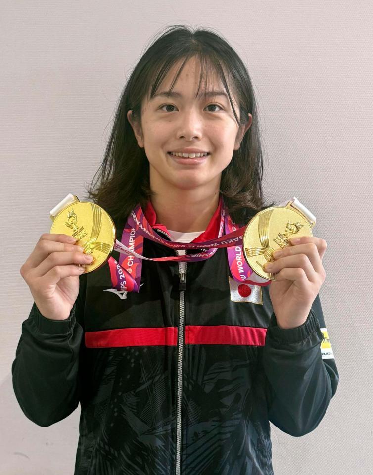 帰国し、成田空港でメダルを手に写真撮影に応じる柔道女子57キロ級の大森朱莉＝13日