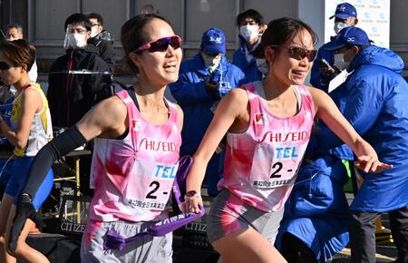 ２２年の全日本実業団女子駅伝　資生堂の３区・一山麻緒（右）に笑顔でたすきをつなぐ２区・佐藤成葉