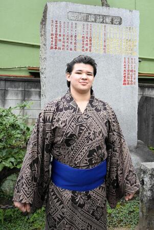 師匠の武蔵川親方のしこ名、武蔵丸が刻まれた横綱石碑の前で撮影に応じる砂武蔵
