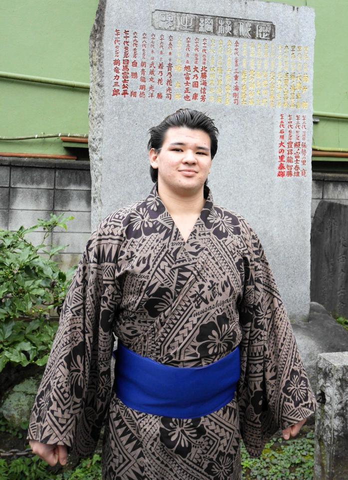 　横綱石碑の前で撮影に応じる砂武蔵