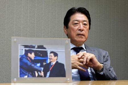 　インタビューに応じる日本ラグビー協会の土田会長。手前は平尾誠二さんとの写真