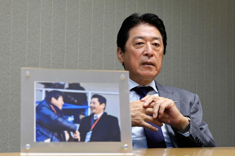 　インタビューに応じる日本ラグビー協会の土田会長。手前は平尾誠二さんとの写真