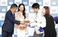 婚約祝の花束とケーキをエアウィーヴ高岡本州会長兼社長（左）とブランドアンバサダーの浅田真央さんからプレゼントされる木原龍一と三浦璃来（撮影・持木克友）