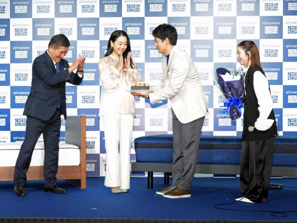婚約祝の花束とケーキをエアウィーヴ高岡本州会長兼社長（左）とブランドアンバサダーの浅田真央さんからプレゼントされる木原龍一と三浦璃来（撮影・持木克友）