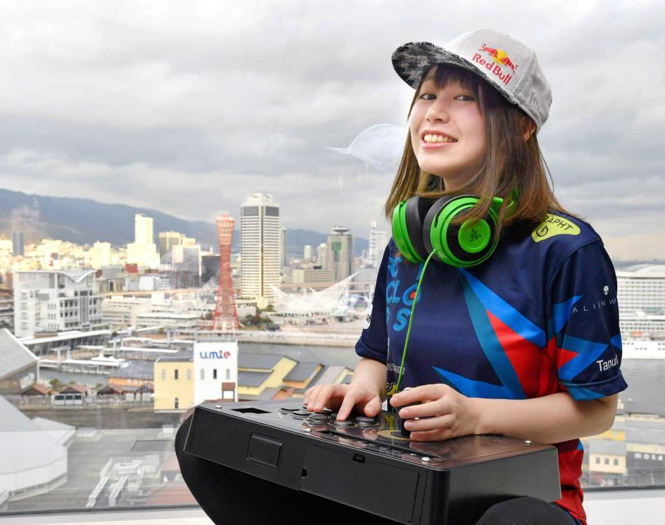 神戸の港を背に愛用のコントローラーを手にする、たぬかな（撮影・持木克友）