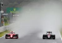 水しぶきを上げ１３０Ｒに飛び込むフェラーリのキミ・ライコネン。右はマクラーレン・ホンダのジェンソン・バトン＝鈴鹿サーキット（撮影・神子素慎一）