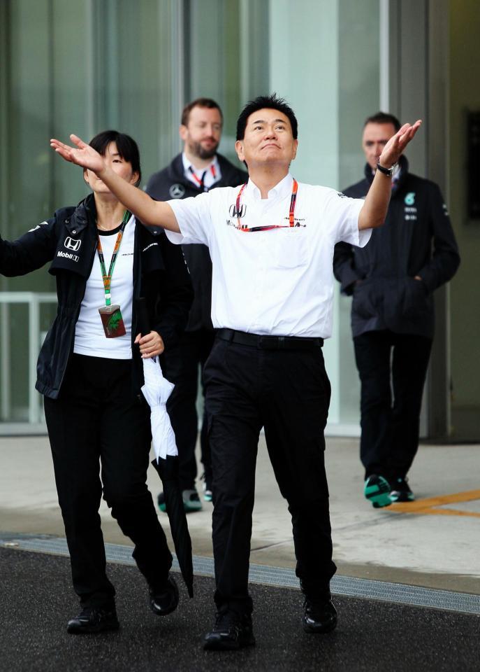 両手を広げ降り止んだ雨を確かめるＦ１プロジェクト総責任者の新井康久氏＝鈴鹿サーキット（撮影・神子素慎一）