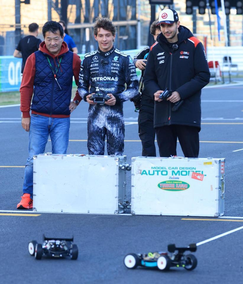 コースでラジコンを楽しむメルセデスのアンドレア・キミ・アントネッリ（中央）とハース・フェラーリのエステバン・オコン（右）＝鈴鹿サーキット（撮影・神子素慎一）