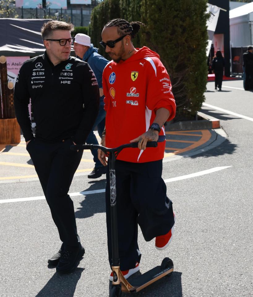 メルセデスの関係者と談笑するフェラーリのルイス・ハミルトンハミルトン（右）＝鈴鹿サーキット（撮影・神子素慎一）