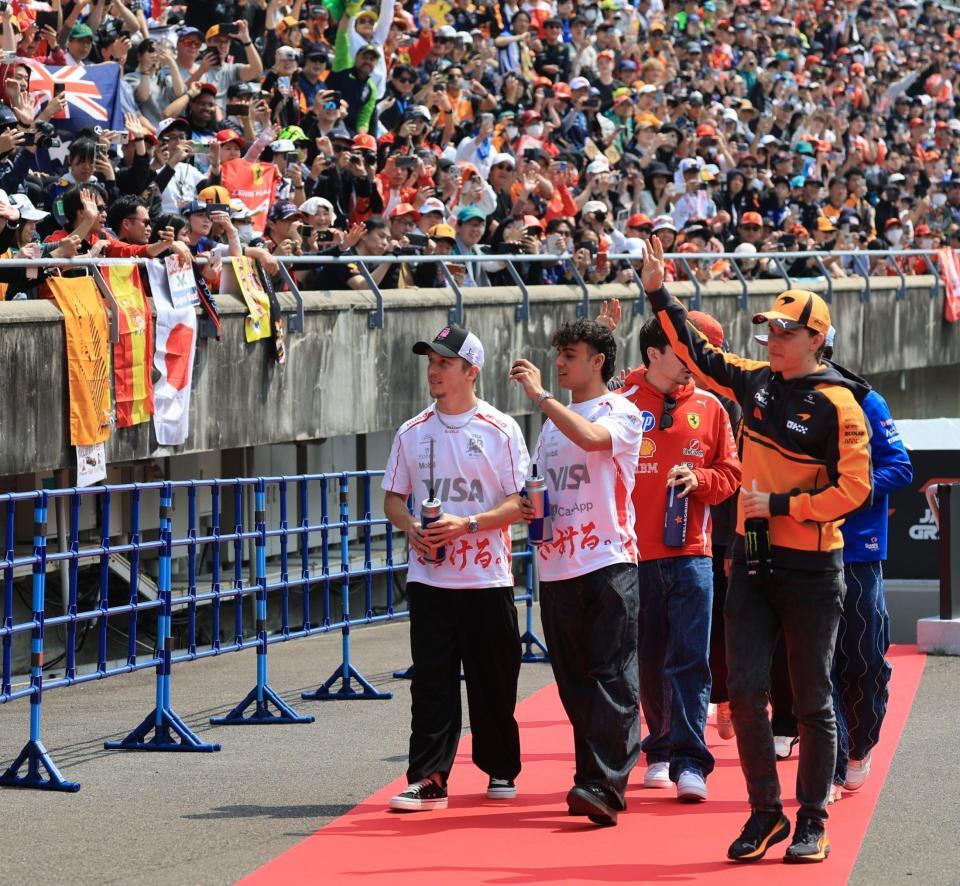 ドライバーズパレードに参加したレーシングブルズ・フォードのリアム・ローソン（左）＝鈴鹿サーキット（撮影・神子素慎一）