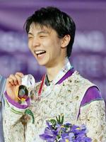 フィギュアスケートのＧＰファイナルで男子初となる３連覇を達成し、メダルを手に笑顔の羽生結弦＝12日、バルセロナ（共同）