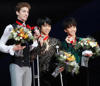 ロシア杯男子で優勝し、松葉づえ姿で表彰台に上がり笑顔の羽生結弦（中央）。右は３位の友野一希＝モスクワ（共同）